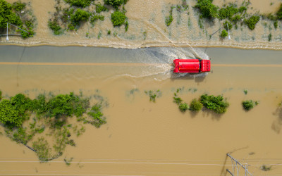 Aerial top view of Flooded the village and Country road with a red car, View from above shot by drone